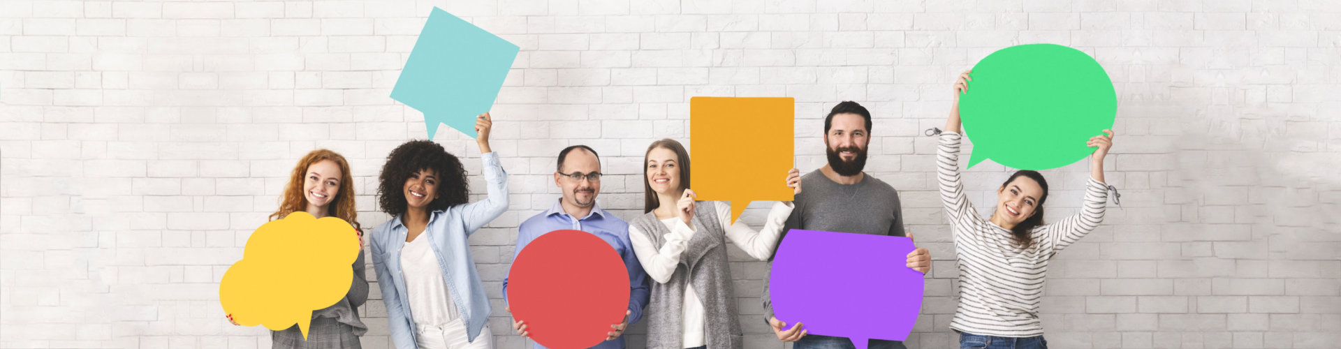 Group of diverse people holding colorful speech bubbles